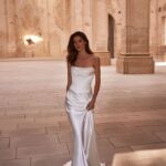 A woman in white dress standing on the ground.