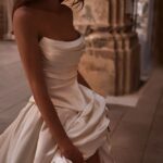 A woman in white dress standing on the floor.