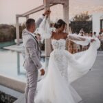 A man and woman dancing in front of an outdoor pool.