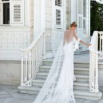 A bride in a white dress standing on steps.